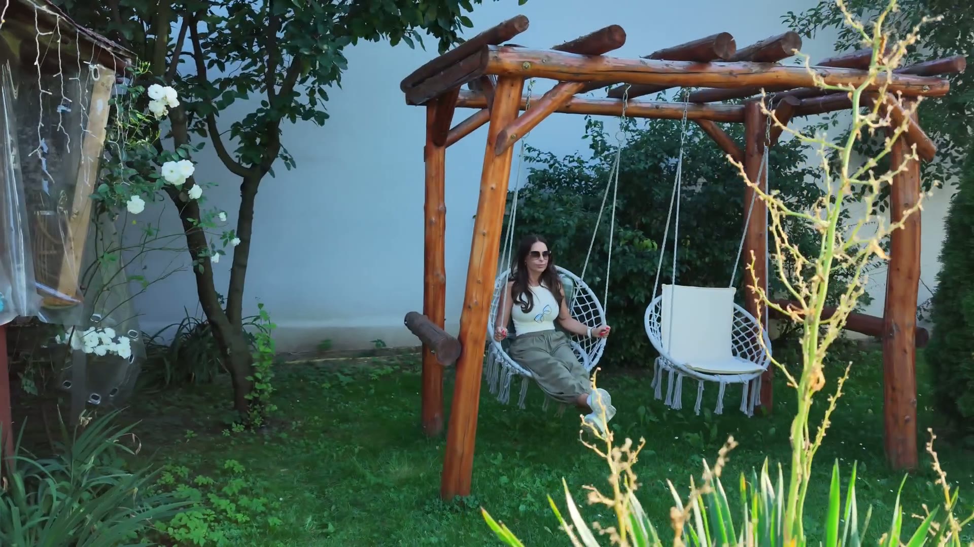 Leagănele de sub pergola de lemn din curtea pensiunii