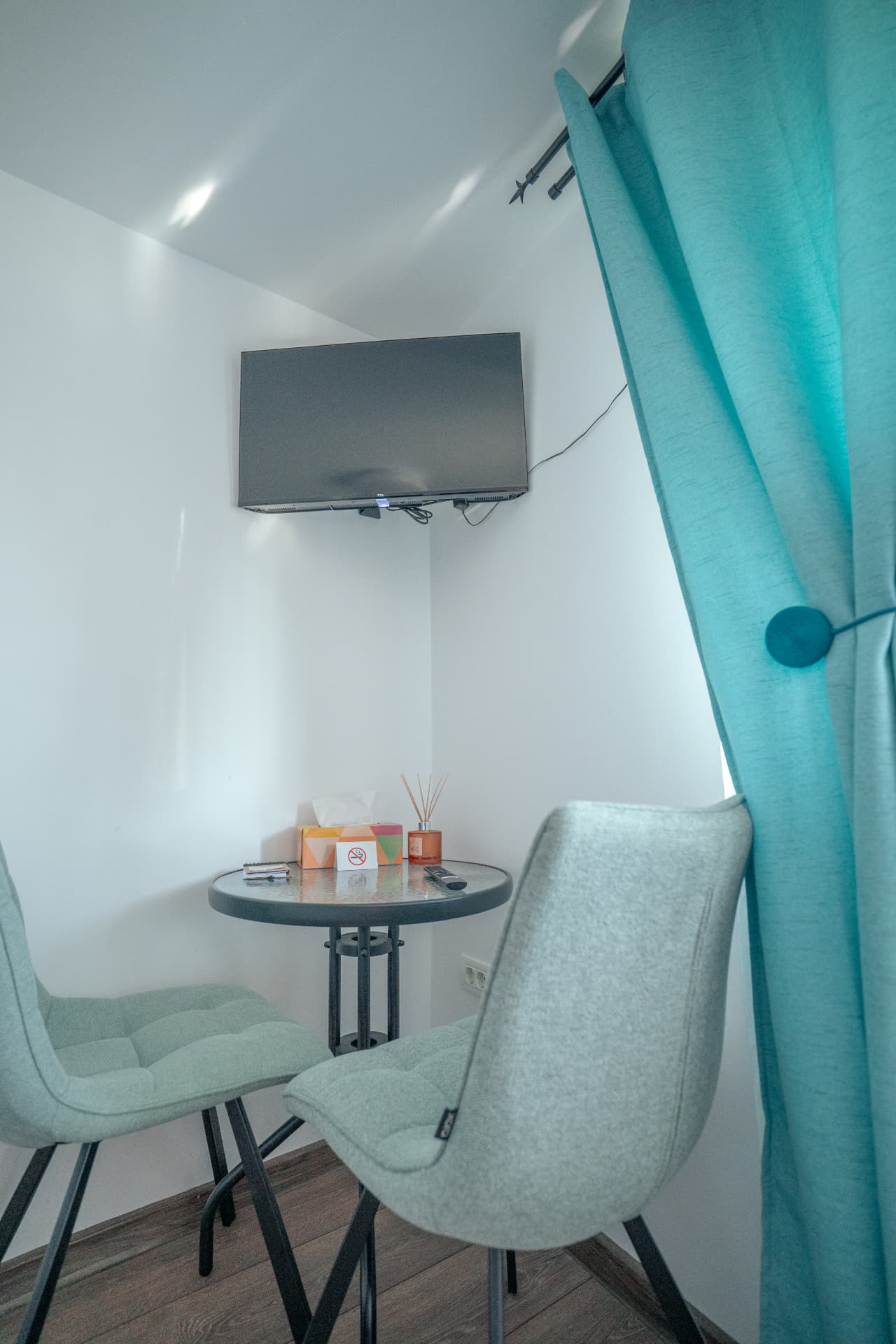 Colțul de relaxare din cameră, cu masă, fotolii și televizor